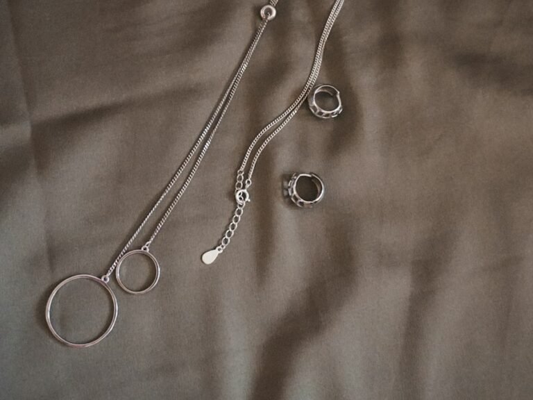 Sterling silver chains and rings on soft fabric