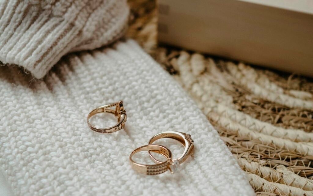 Gold rings resting on a cream knit sweater