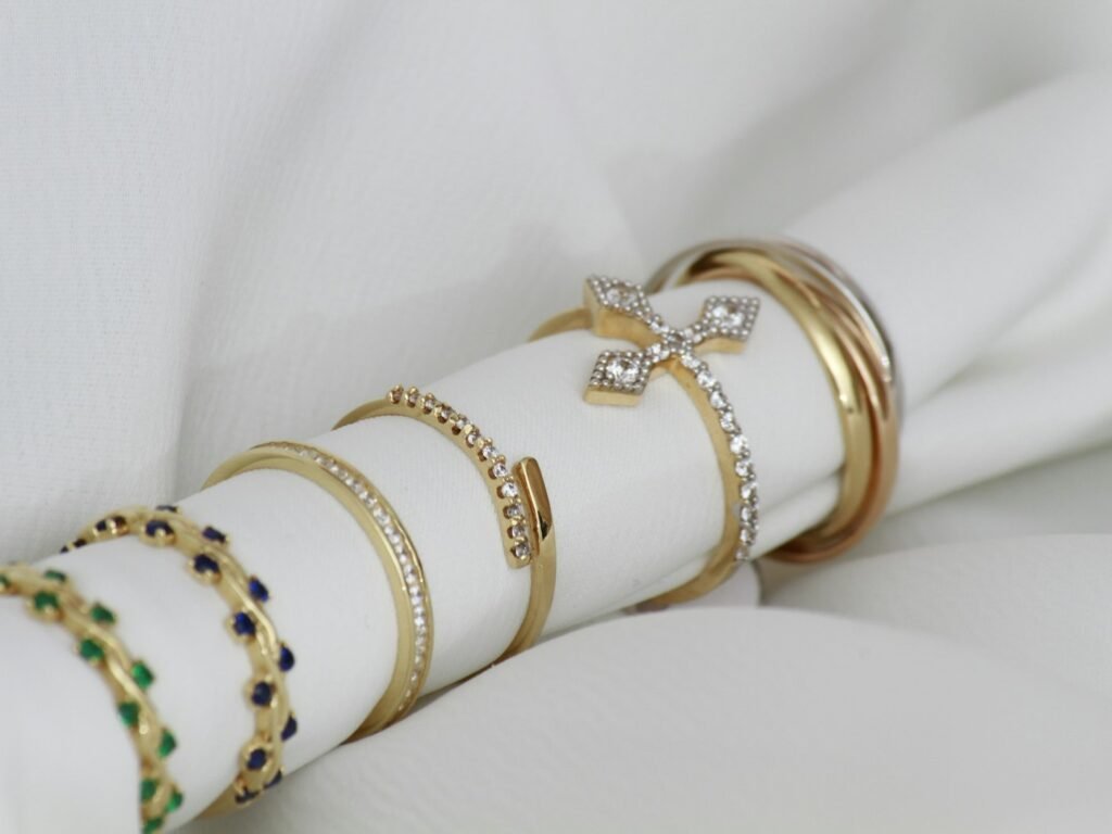 Stacked gold and silver rings on a soft white cloth for cleaning