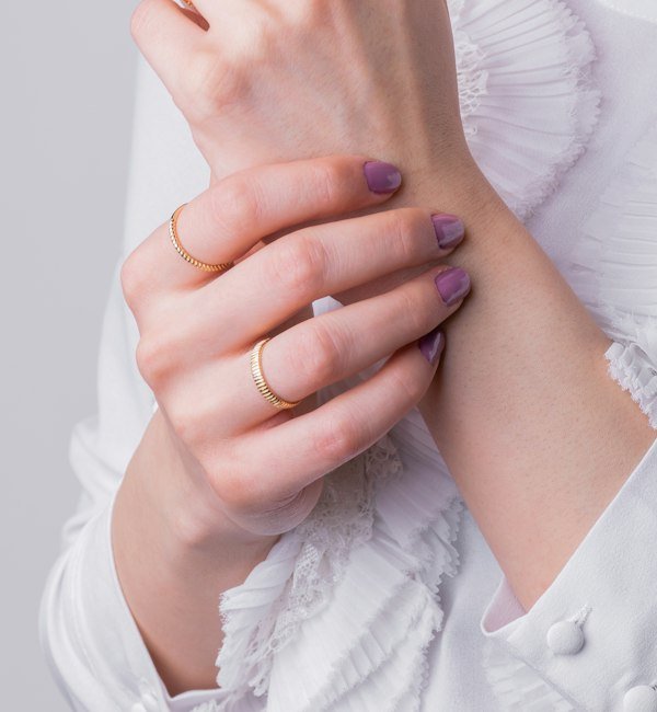 Gold rings stacked on a hand against white lace