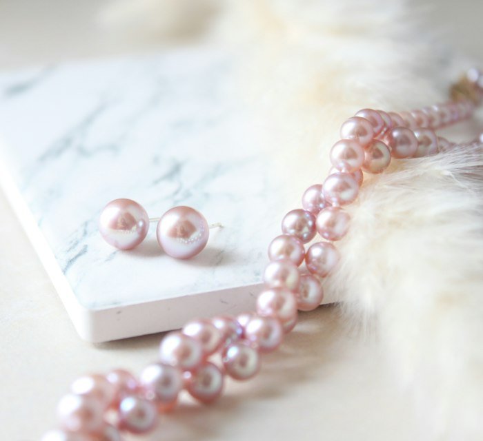 Blush pearl necklace and earrings on marble