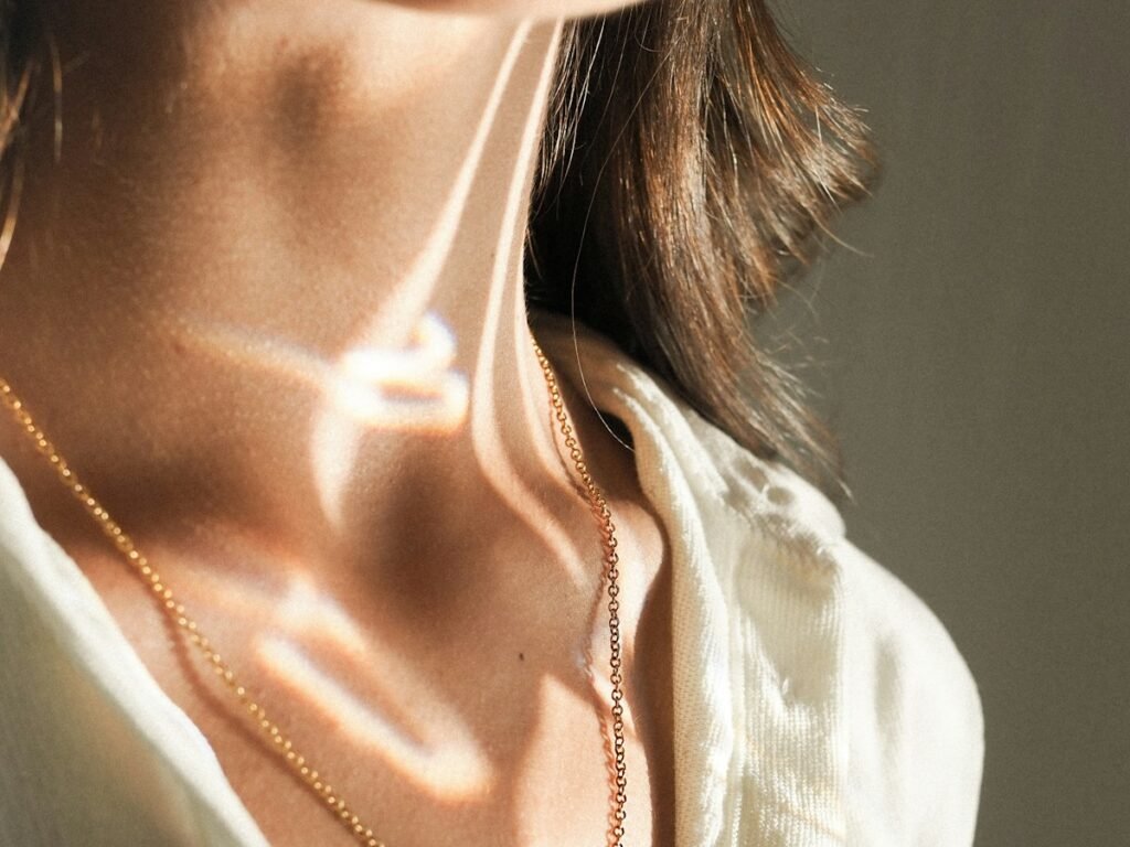 Gold necklace on the collarbone in warm daylight