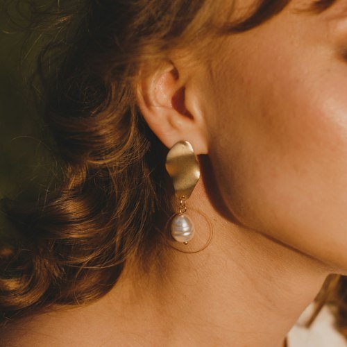 Gold drop earring on a woman