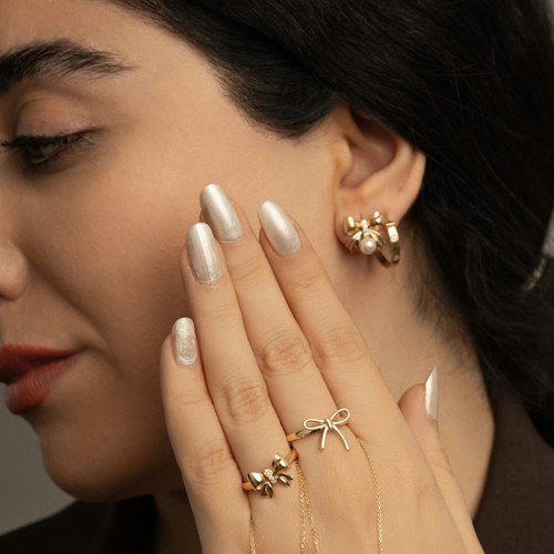 Hand with gold rings and earrings